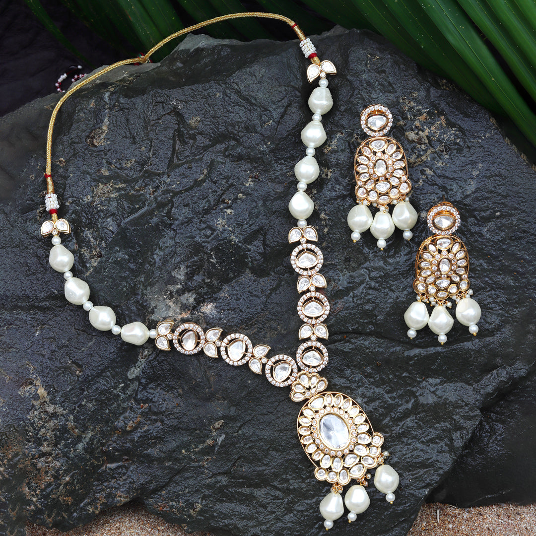 Gold finished Polki Necklace Set Adorned With White Pearls, Accompanied By Matching Danglers.